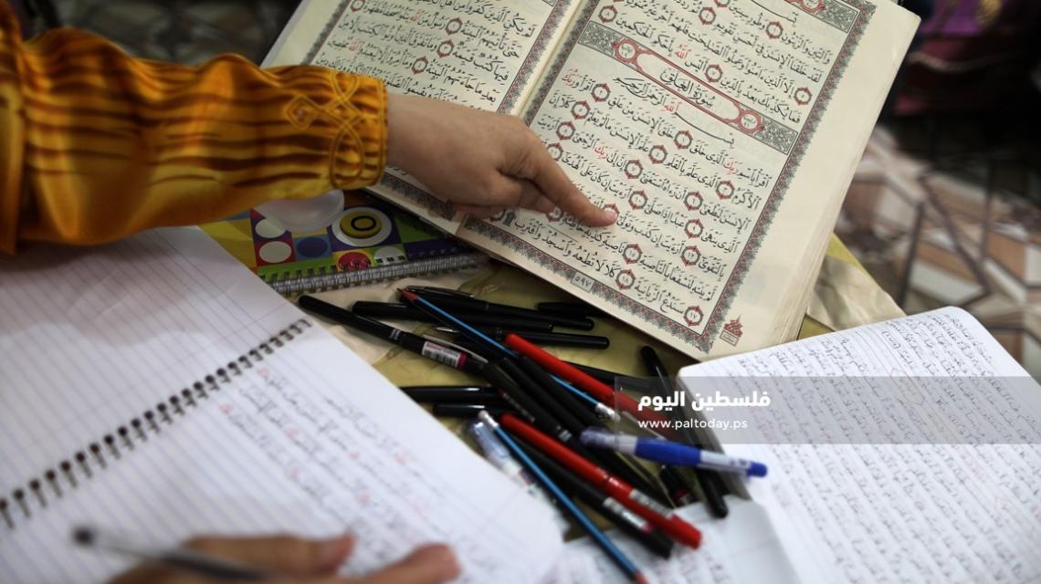 سيدة من غزة تعمل على كتابة القرآن الكريم كاملا بخط يدها