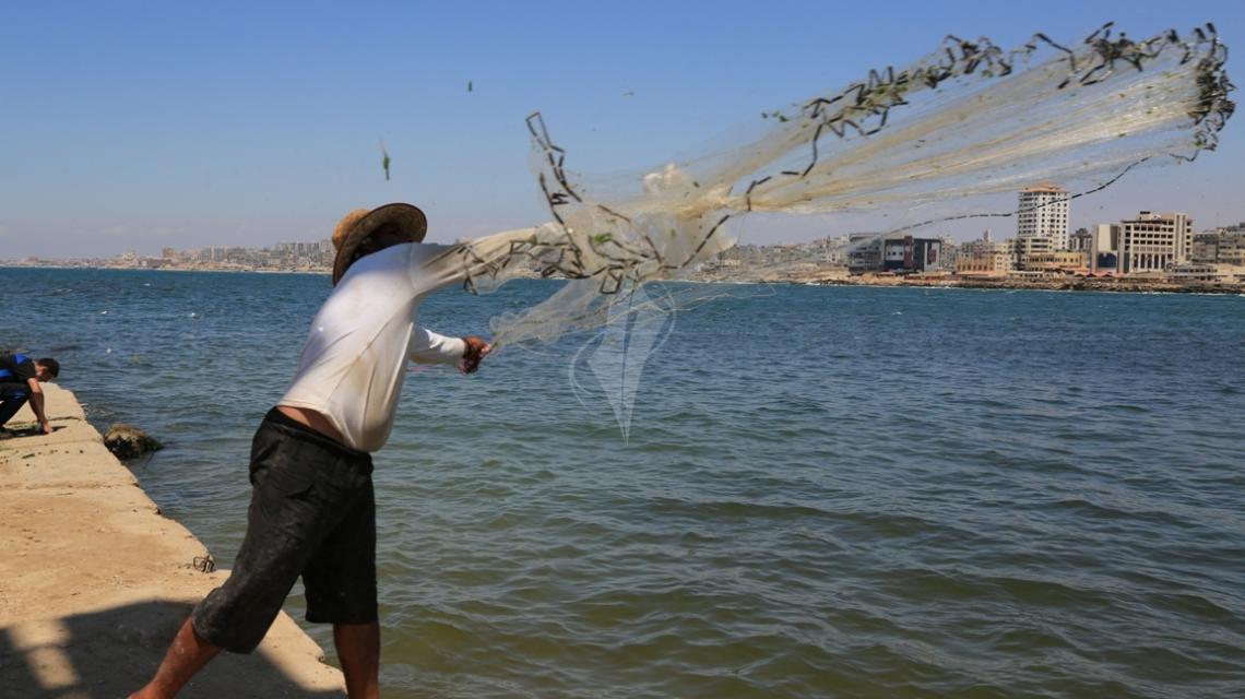 بالصور:صياد فلسطيني يبحث عن رزقه في بحر غزة في شهر رمضان المبارك