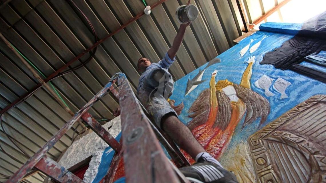 بالصور:شاب فلسطينى  بقدم واحدة يبدع فى رسم اللوحات الفنية بغزة