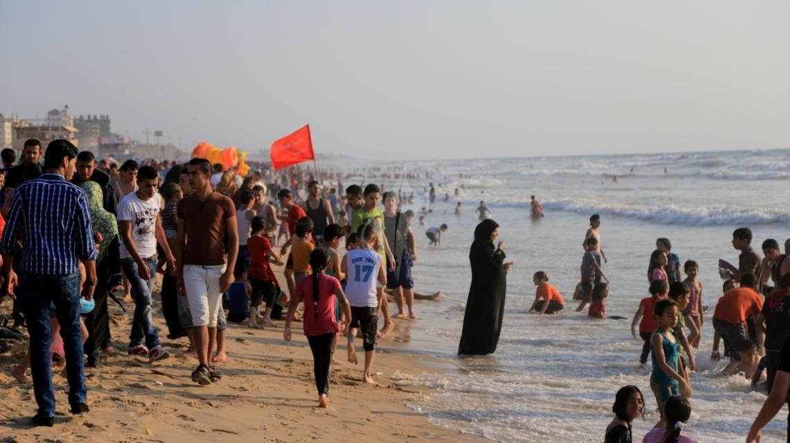 بالصور:الغزيون يفرون إلى البحر مع ارتفاع درجات الحرارة