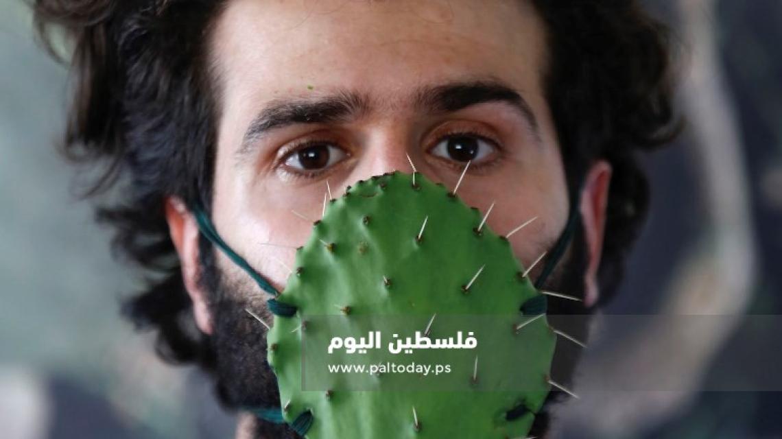 الفنان أحمد ياسين يشكل من ألواح الصبر قناعاً في إطار توعوي لإبراز أهمية قناع الوجه وسط انتشا