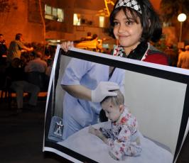 اطفال غزة يرفعون صور ضحايا العدوان على غزة تضامنا معهم
