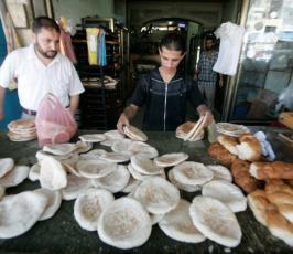 بالصور:: عمال غزيين بمخبز يستعدون لعيد الفطر السعيد