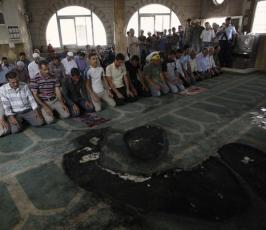 بالصور : مصلون فلسطينيون يؤدون الصلاة داخل مسجد تم حرقة من قبل المستوطنين
