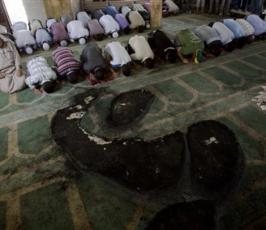 بالصور : مصلون فلسطينيون يؤدون الصلاة داخل مسجد تم حرقة من قبل المستوطنين