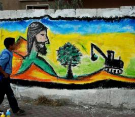 بالصور:: شباب غزيون يرسمون على جدران غزة بيوم التراث الفلسطينى