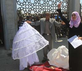 تقرير مصور : عروس تلقي بدلة زفافها وسط معبر رفح