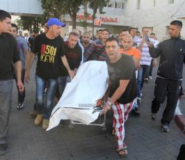ذوو الشهيد محمد محمود اسماعيل الطريفي يلقون نظرة الوداع على جثمانه في مجمع فلسطين الطبي