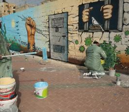 منتدى الفن التشكيلي ووزارة الاسرى يتضامنون مع الاسرى في سجون الاحتلال برسم جدارية عن فيروس كورونا (7).JPG