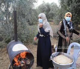 فلسطينيات يعددن الخبز على الصاج  خلال افتتاح موسم جني الزيتون بغزة (2)