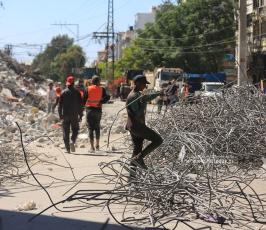 عمال مصريين يقومون بازلة ركام المنازل المدمرة خلال معركة سيف القدس (2)