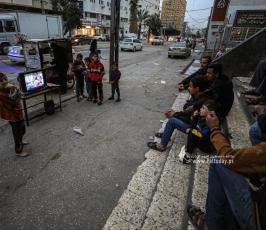 مواطنون يشاهدون مباراة المنتخب المغربي عبر شاشة تلفاز قديم على إحدى الطرقات بقطاع غزة (1)