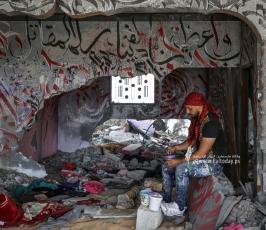 الفنان الفلسطيني أيمن الحصري يرسم جدرايات بالخط العربي على أحد المنازل التي دمرت بفعل قصف الاح