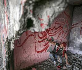 الفنان الفلسطيني أيمن الحصري يرسم جدرايات بالخط العربي على أحد المنازل التي دمرت بفعل قصف الاح (8)