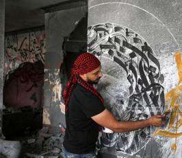 الفنان الفلسطيني أيمن الحصري يرسم جدرايات بالخط العربي على أحد المنازل التي دمرت بفعل قصف الاح (10)