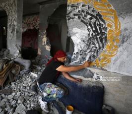 الفنان الفلسطيني أيمن الحصري يرسم جدرايات بالخط العربي على أحد المنازل التي دمرت بفعل قصف الاح (7)