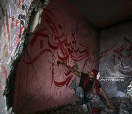 الفنان الفلسطيني أيمن الحصري يرسم جدرايات بالخط العربي على أحد المنازل التي دمرت بفعل قصف الاح (3)