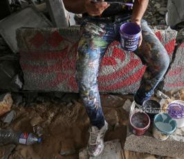 الفنان الفلسطيني أيمن الحصري يرسم جدرايات بالخط العربي على أحد المنازل التي دمرت بفعل قصف الاح (9)