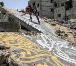الفنان الفلسطيني أيمن الحصري يرسم جدرايات بالخط العربي على أحد المنازل التي دمرت بفعل قصف الاح (5)