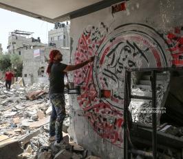 الفنان الفلسطيني أيمن الحصري يرسم جدرايات بالخط العربي على أحد المنازل التي دمرت بفعل قصف الاح (6)