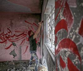 الفنان الفلسطيني أيمن الحصري يرسم جدرايات بالخط العربي على أحد المنازل التي دمرت بفعل قصف الاح (11)