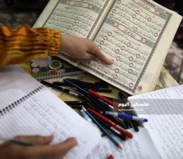 سيدة من غزة تعمل على كتابة القرآن الكريم كاملا بخط يدها (7).jpg