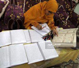سيدة من غزة تعمل على كتابة القرآن الكريم كاملا بخط يدها (8).jpg