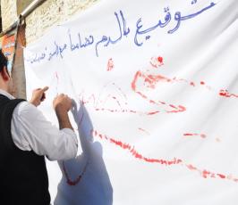 متضامنون فى غزة يوقعون بدمائهم اسم الشيخ خضر عدنان