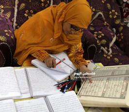 سيدة من غزة تعمل على كتابة القرآن الكريم كاملا بخط يدها (9).jpg