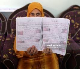 سيدة من غزة تعمل على كتابة القرآن الكريم كاملا بخط يدها (3).jpg