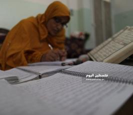 سيدة من غزة تعمل على كتابة القرآن الكريم كاملا بخط يدها (5).jpg
