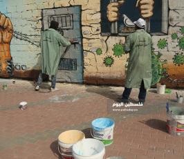 منتدى الفن التشكيلي ووزارة الاسرى يتضامنون مع الاسرى في سجون الاحتلال برسم جدارية عن فيروس كورونا (16).JPG