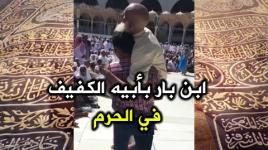 رجل يساعد والده الكفيف في تقبيل الحجر الأسود