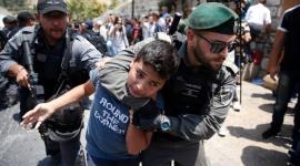 جندي إسرائيلي يعتدي على طفل فلسطيني.jpg