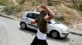 شاب يرشق مركبة مستوطن بالحجارة في الضفة الغربية المحتلة (أرشيفية)