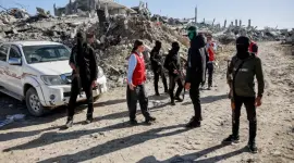 عناصر من القسام بجانب قوة من الصليب الاحمر خلال البحث عن أسرى إسرائيليين في غزة (ارشيفية)
