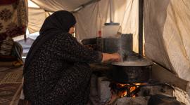 امرأة تطهو داخل الخيمة