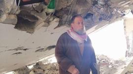 صورة والدة الشهيد صالح البرغوثي يقف على انقاض منزله المدمر