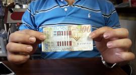 صورة ارشيفية ل100 شيقل مع احد الطلاب