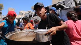 مواطنون يتجمعون أمام مطبخ خيري بانتظار استلام وجبات الطعام، في غرب مدينة غزة، في ظل استمرار الأزمة الإنسانية ونقص المواد الغذائية