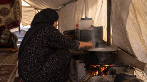 امرأة تطهو داخل الخيمة