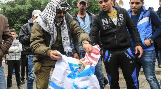 فلسطينيون يحرقون علم أمريكا في غزة
