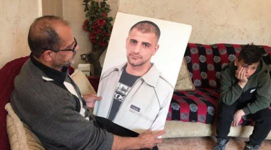 والد الأسير يحمل صورة ابنه حسين مسالمة