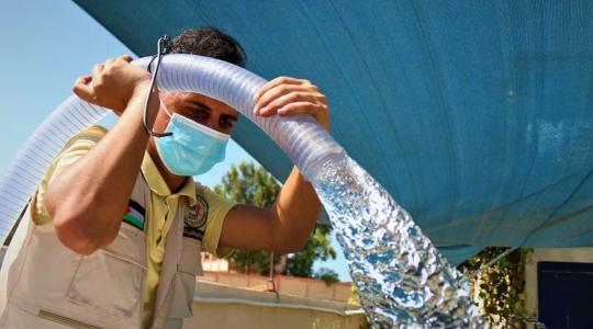 شخص يقوم بتعبئة مياه الشرب في غزة- ارشيف