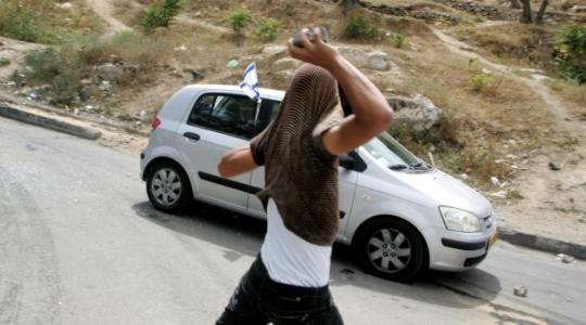 شاب يرشق مركبة مستوطن بالحجارة في الضفة الغربية المحتلة (أرشيفية)