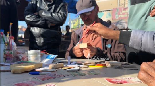 اصلاح النقود5. النازح وائل رشيد يعمل على صيانة وإصلاح النقود بدير البلح