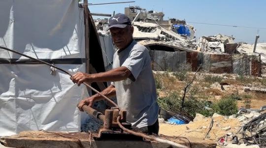 عمال يستخروج الحديد من المناز المدمرة