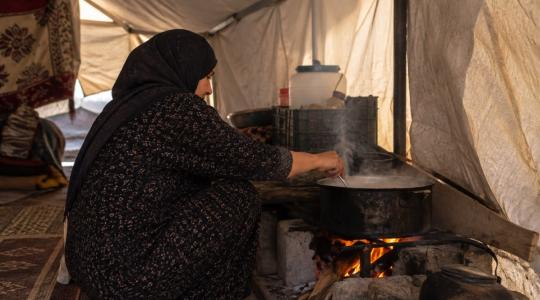 امرأة تطهو داخل الخيمة