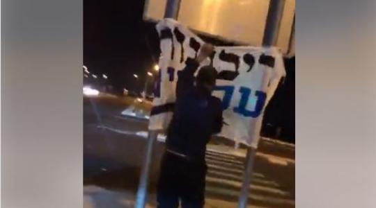 شاب فلسطيني يمزق يافطات اسرائيلية.JPG