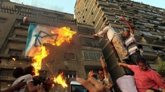 متظاهرون مصريون يحرقون العلم الاسرائيلي ابان اقتحام السفارة الإسرائيلي في القاهرة عام 2011